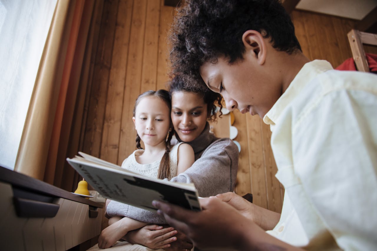 A diverse family enjoys quality time reading together inside a cozy wooden room.